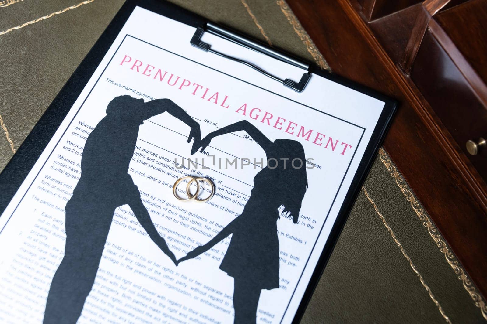 A prenuptial agreement with a silhouette of a couple and wedding rings, symbolizing marital contracts and legal preparation