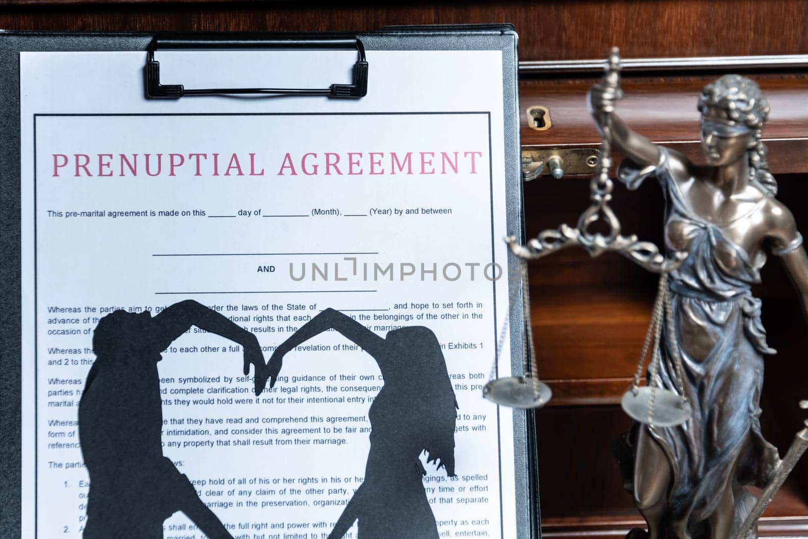 A prenuptial agreement with a silhouette of a couple on a clipboard, with the statue of justice in the background, representing the legalities of marriage. by jbruiz78