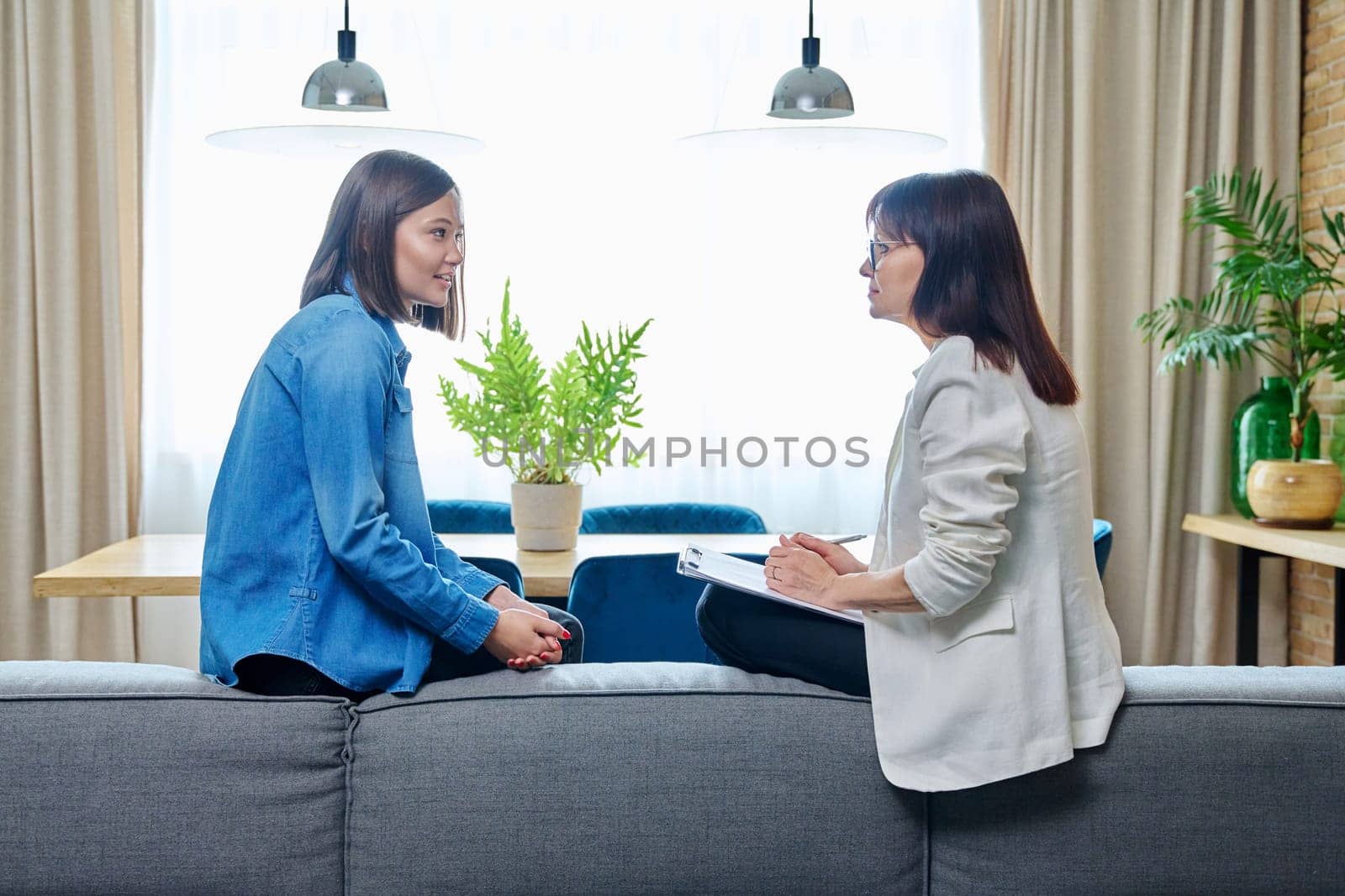 Happy joyful young woman patient talking to female psychologist counselor at therapy session. Positive treatment results, mental health of youth. Psychology psychotherapy support help rehabilitation