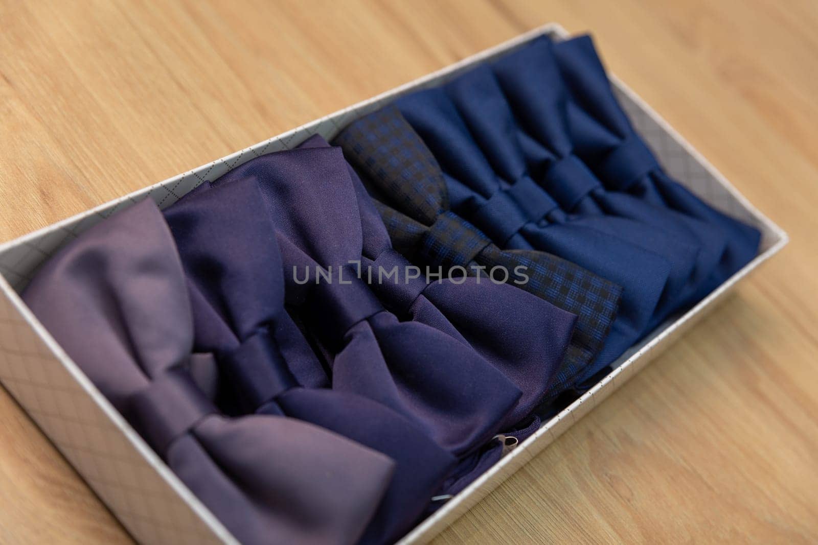 Showcase in a store with beautiful multi-colored bow ties. Many bright colorful beautiful bow ties in an box.
