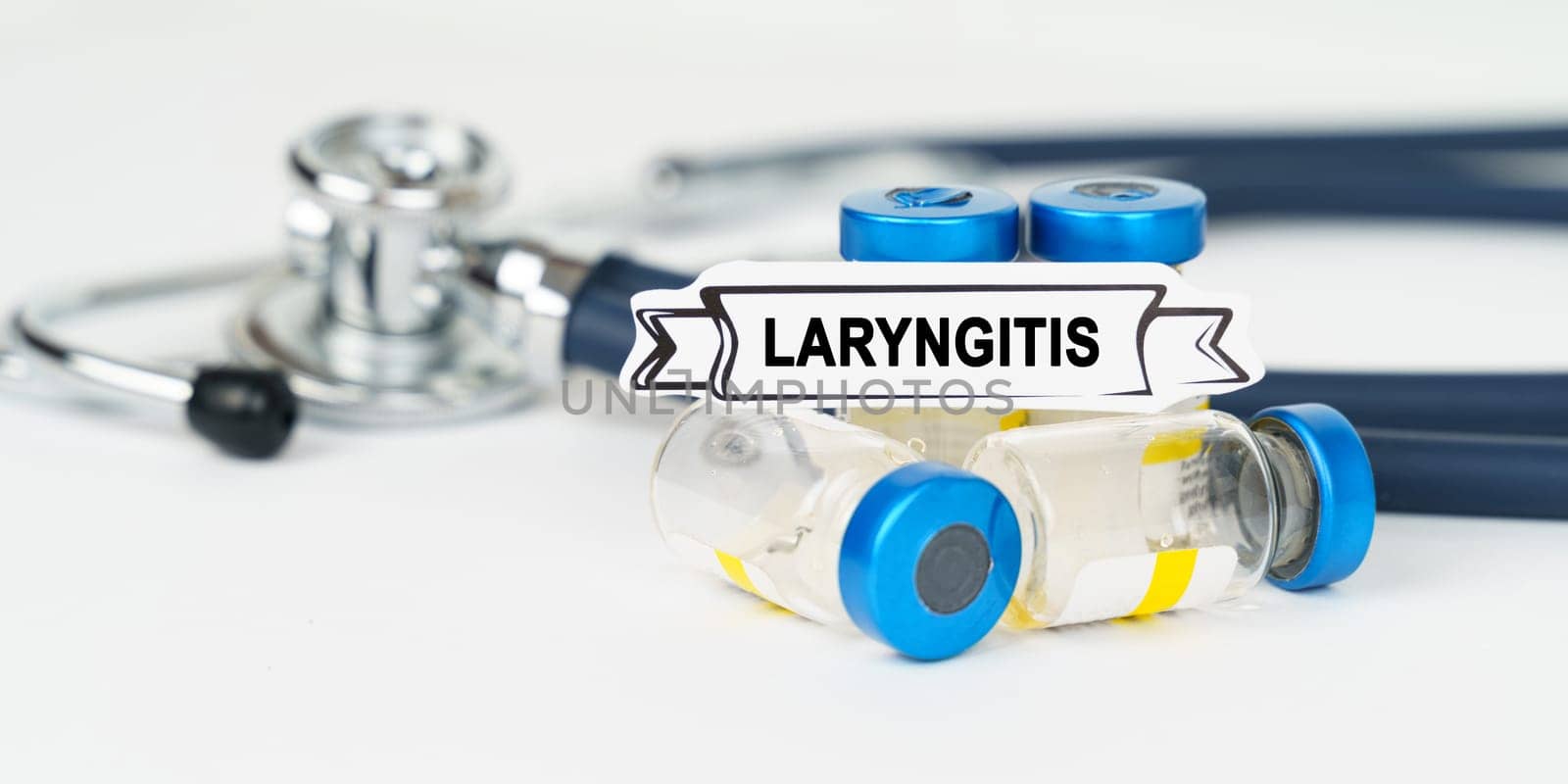 Medical concept. On the table there is a stethoscope, injections and a sign with the inscription - Laryngitis