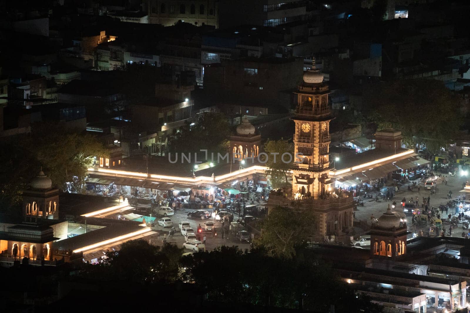 aerial drone shot of clock tower ghanta ghar at night in jodhpur with lights from traffic around shot in India