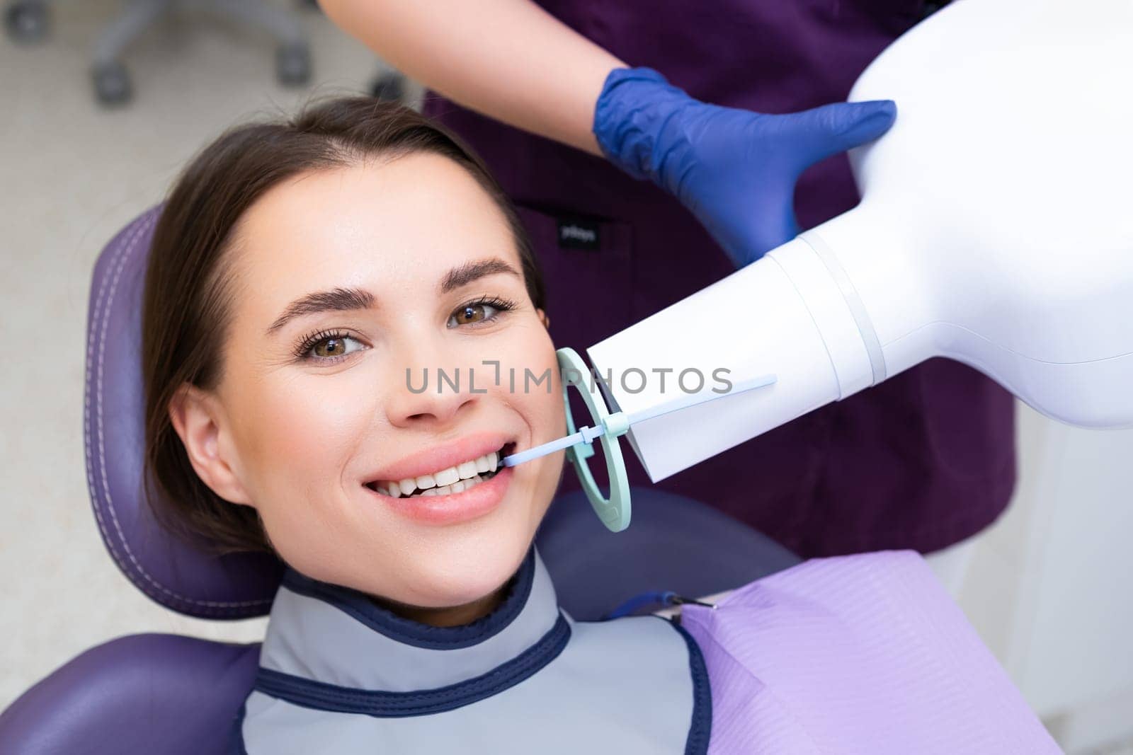 Happy patient during X ray of teeth at the dental clinic.