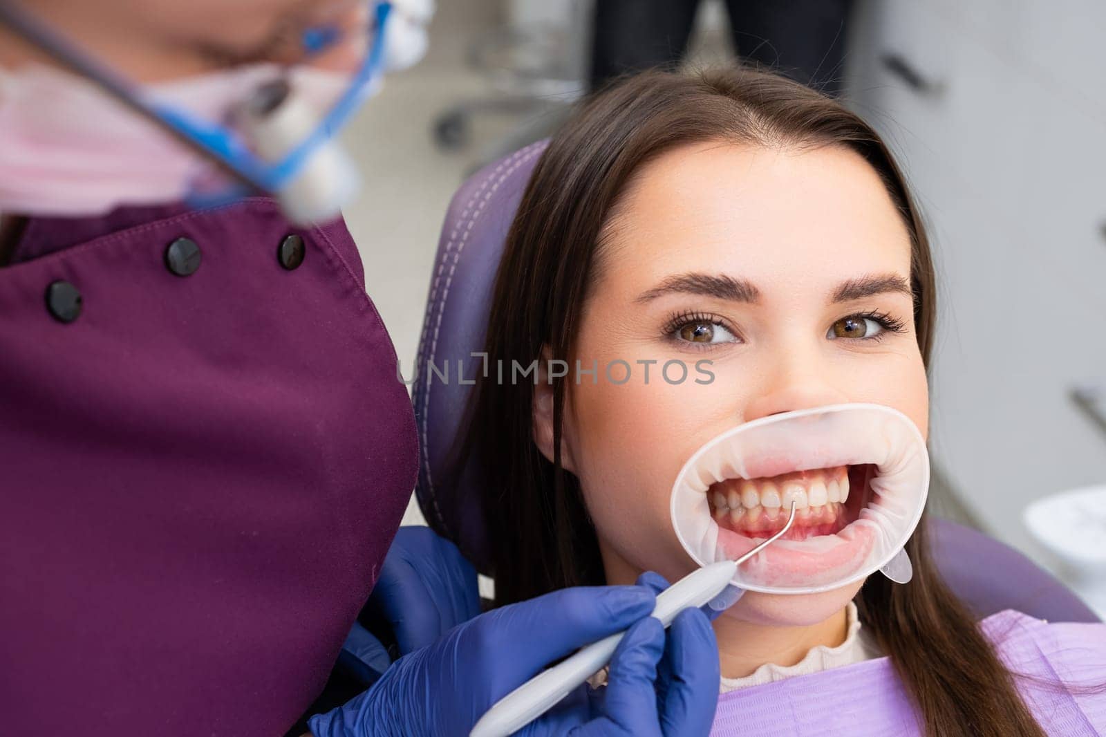 Happy woman getting dental check up in dentists office.