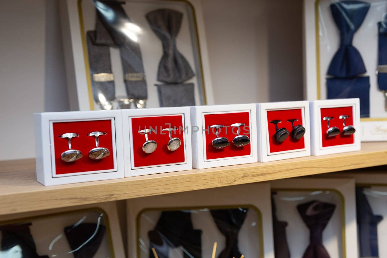 Boxes with cufflinks on shelf in boutique. by BY-_-BY