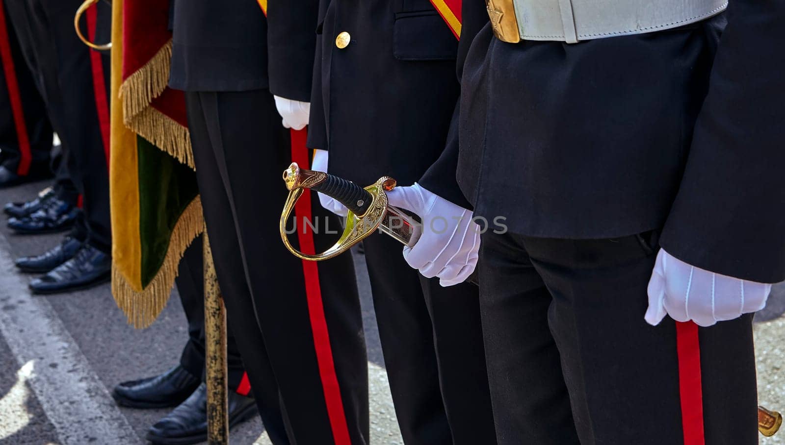 Military honor guard with sword and weapon. A white glove holds a saber for Independence Day.