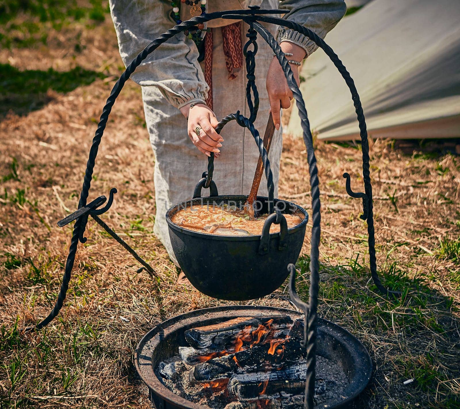 Camping. Soup in a pot over a fire. Stylization under the Middle Ages, vintage.