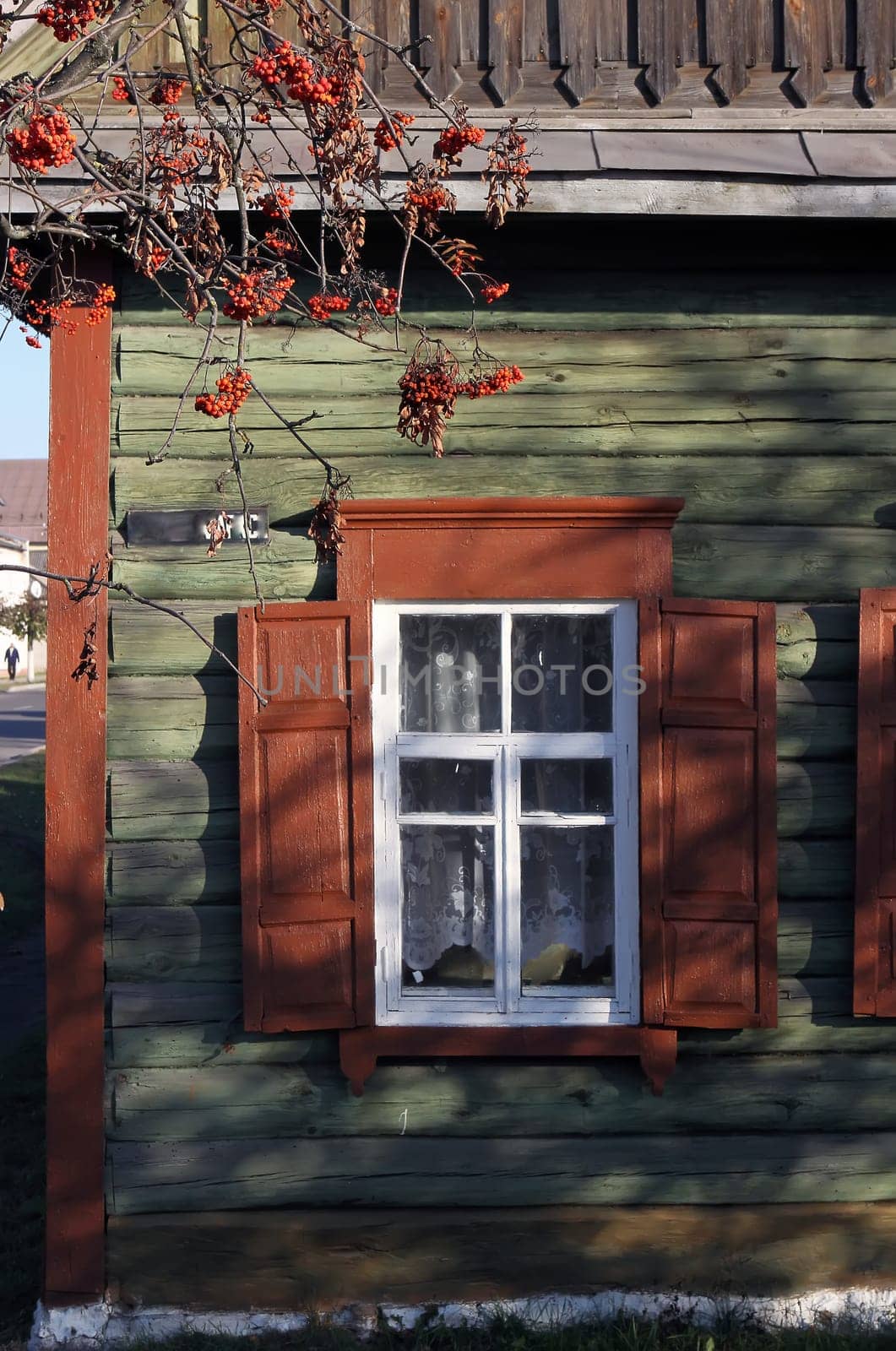 Charming Traditional Wooden House with Vibrant Red Shutters and Stunning Autumn Foliage by Hil