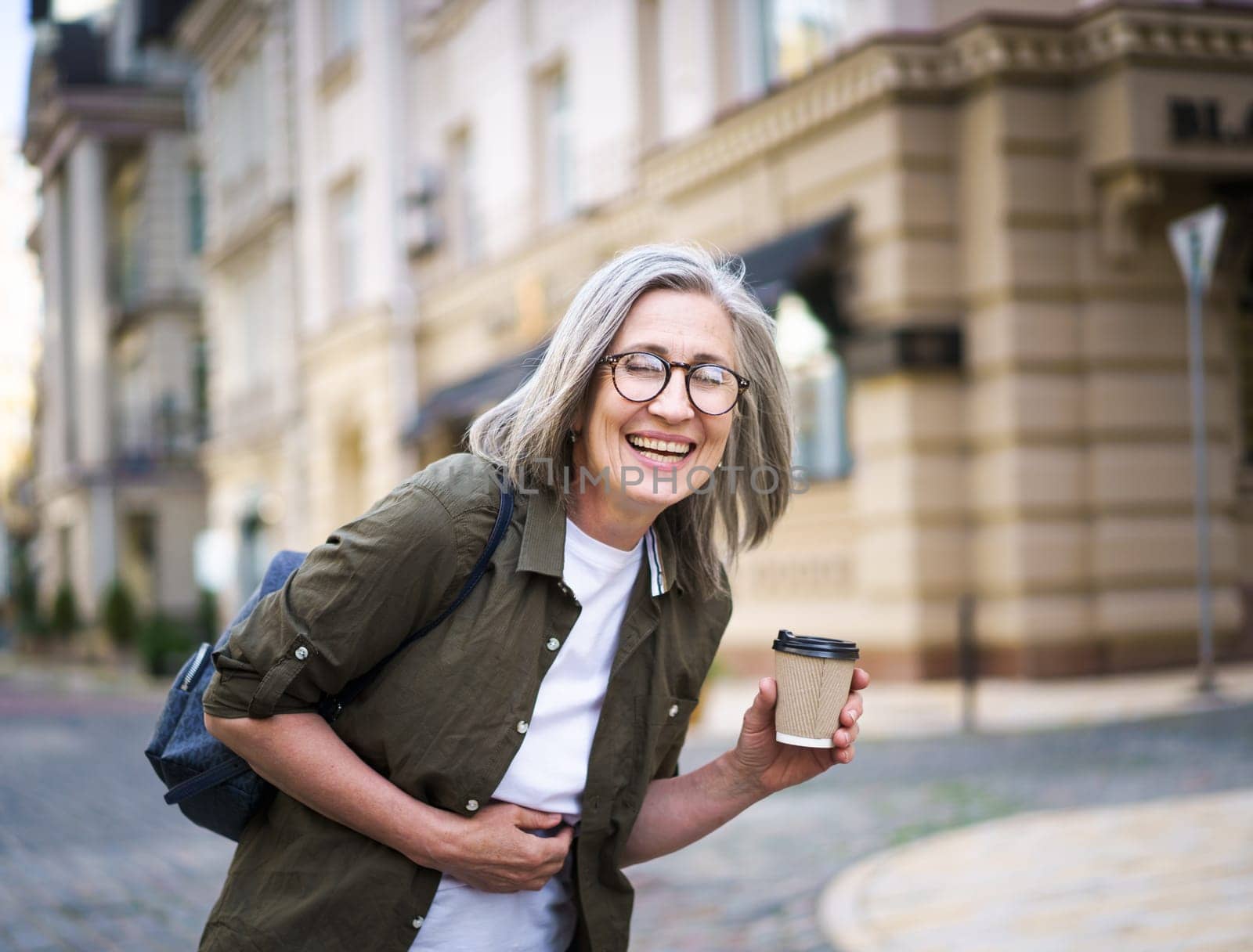 Woman With Glasses Holding a Cup of Coffee by LipikStockMedia
