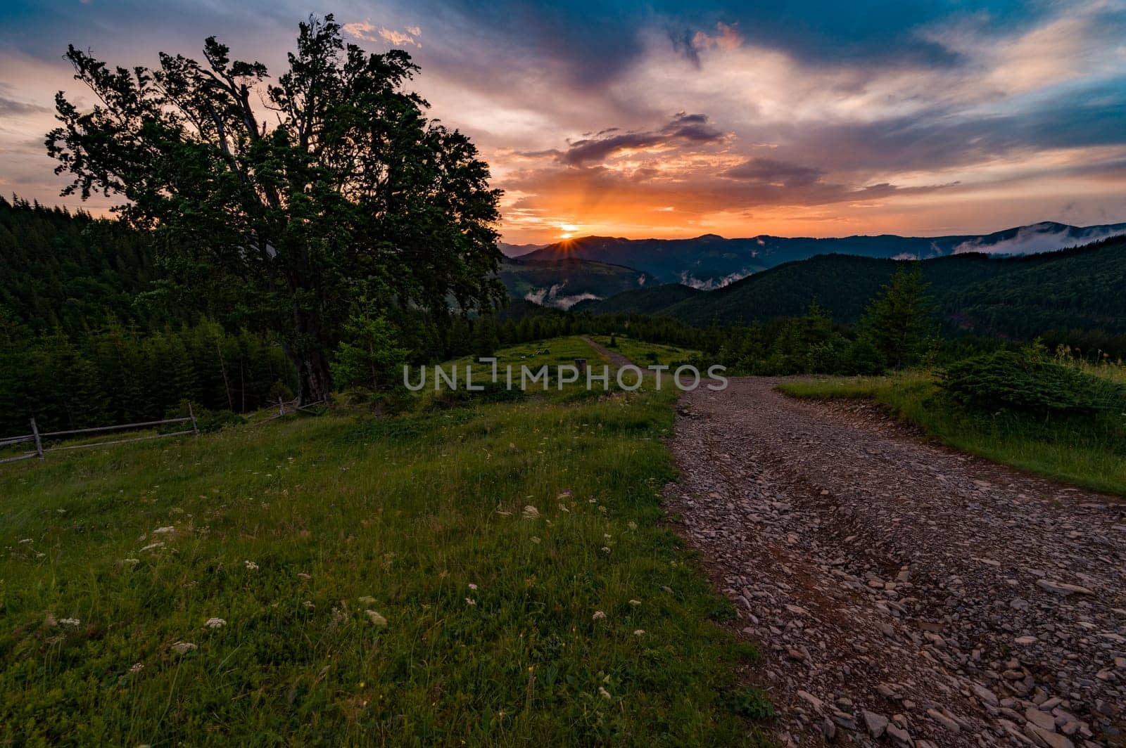 Magical dawn in the Carpathians, in the foreground a road for tourists, fabulous dawns in the mountains.