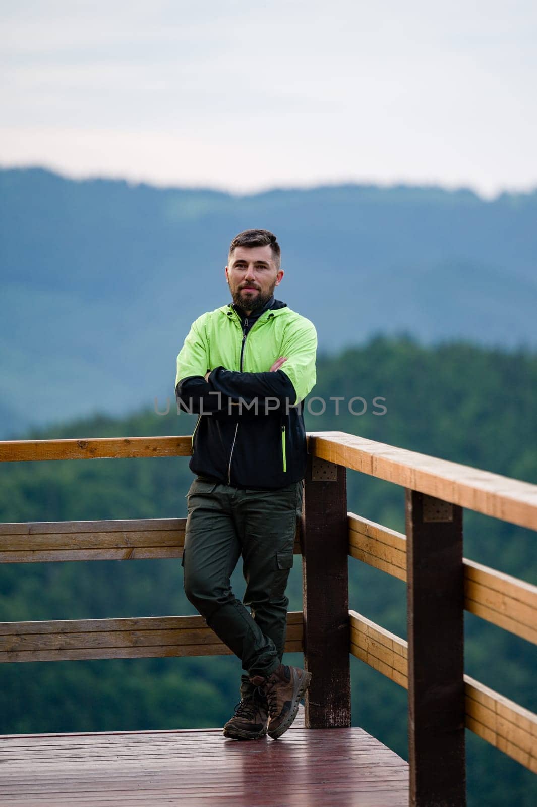 a man in sports clothes stands leaning on a wooden railing on a wooden terrace by Niko_Cingaryuk