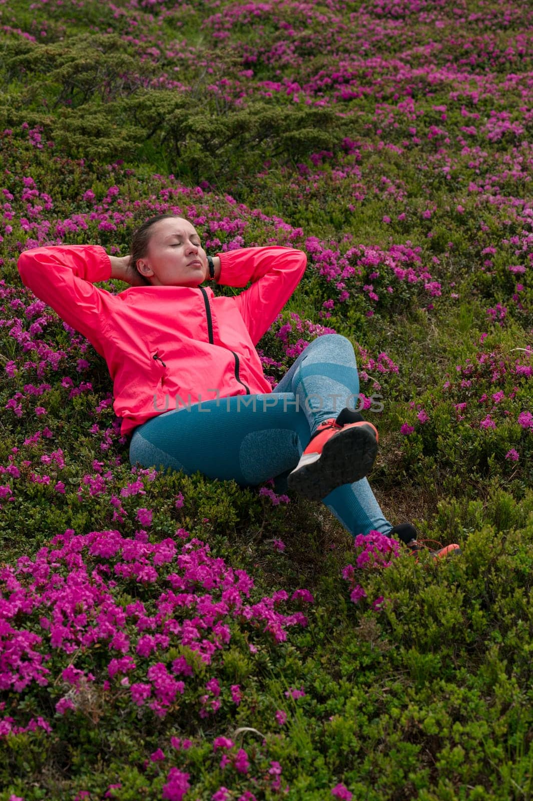 The girl is sitting on the meadow of the Carpathians with rhododendrons. by Niko_Cingaryuk