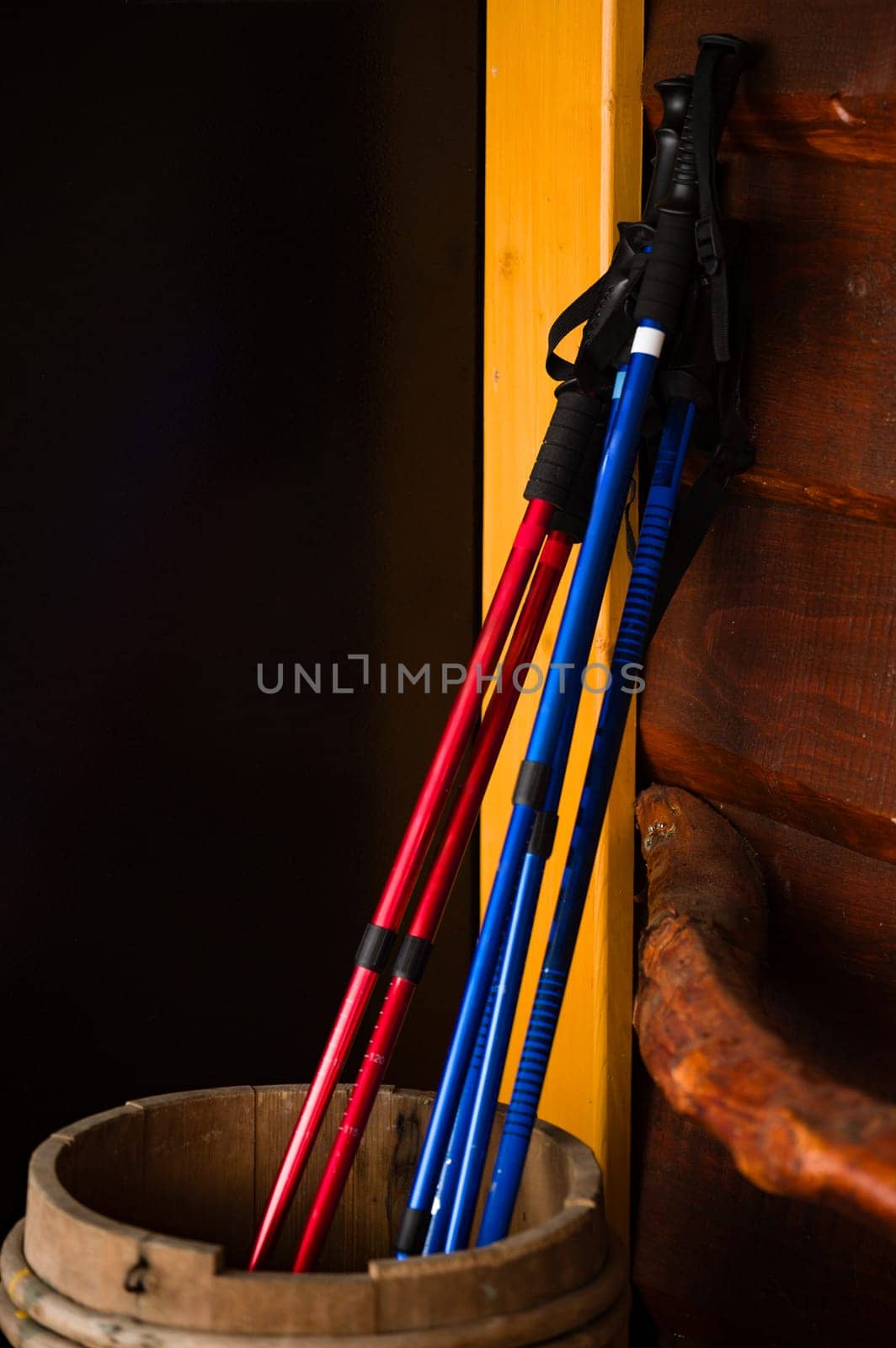 Three pairs of trekking poles are propped up in a barrel, poles for easy walking in the mountains.