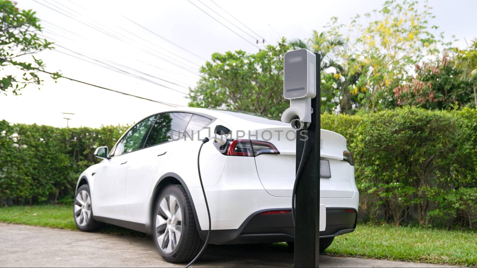 Electric vehicle technology utilized to residential area or home charging station for EV car battery recharge. Eco-friendly transport by clean and sustainable energy for future environment. Synchronos