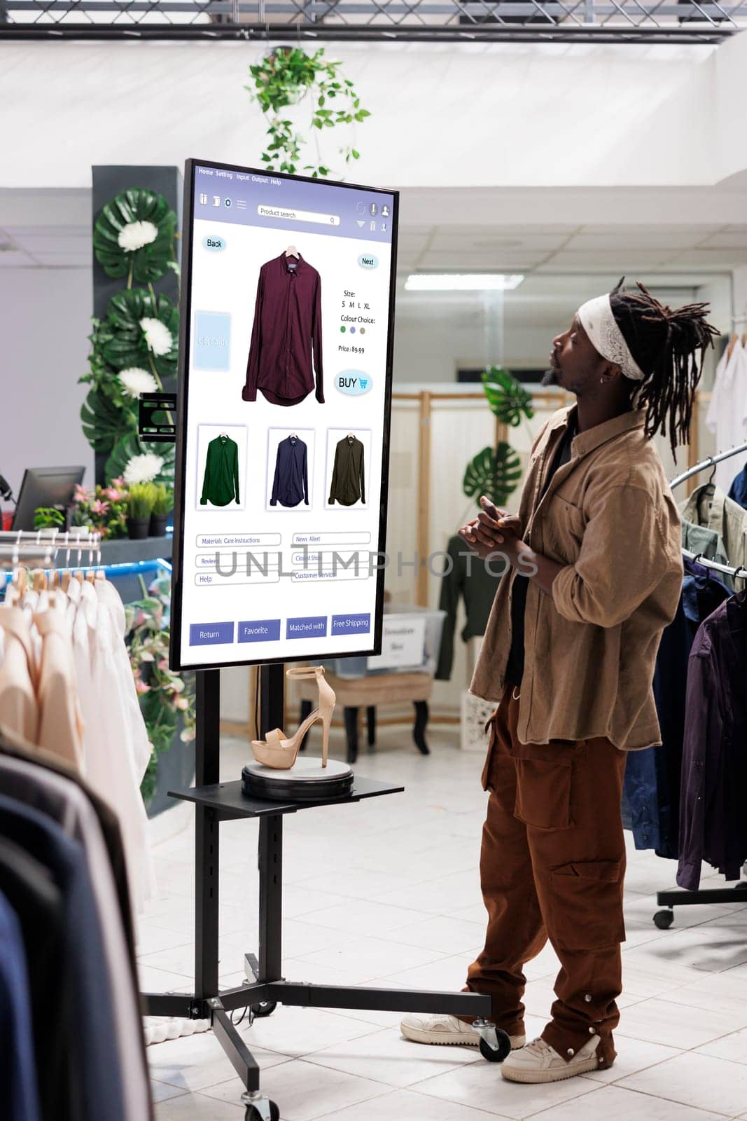 Male client choosing clothes on shopping board kiosk service, buying fashion collection items in clothing store using interactive monitor. Trendy buyer shopping for products, self ordering.