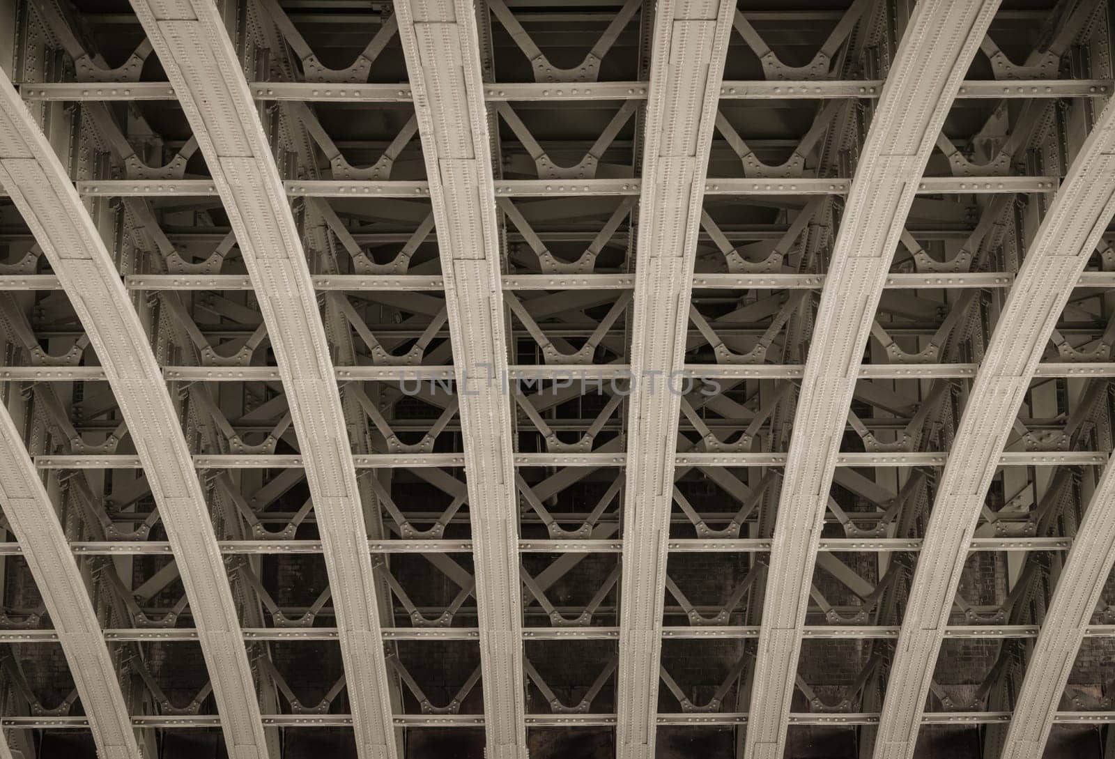 View of Structure and beams under the Curved steel Bridge. Framework metal arches girder construction Underneath of Blackfriars Bridge, Riveted steel beams supporting bridge span, Space for text, Selective focus.