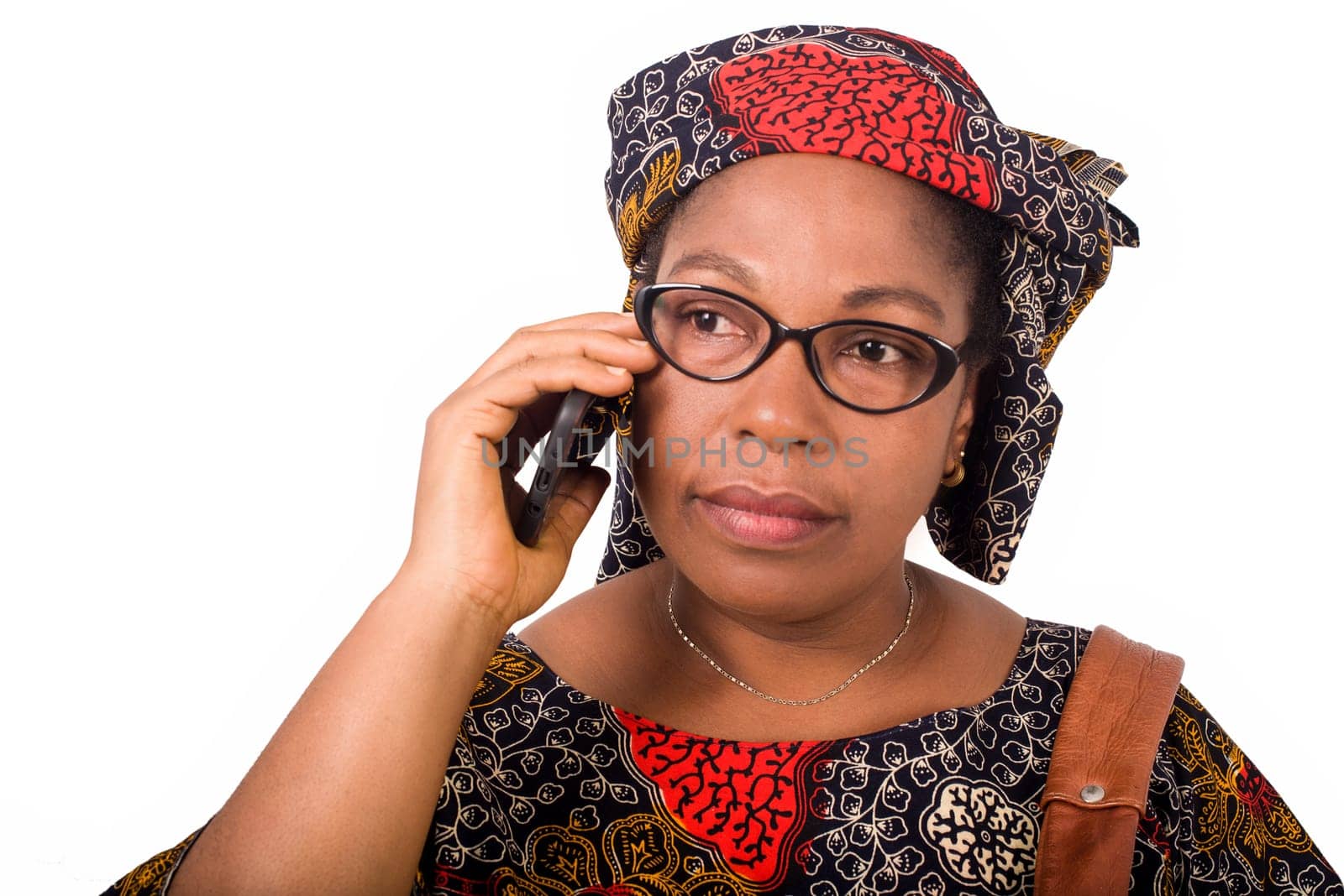 african mature woman in loincloth standing on white background communicating with mobile phone.