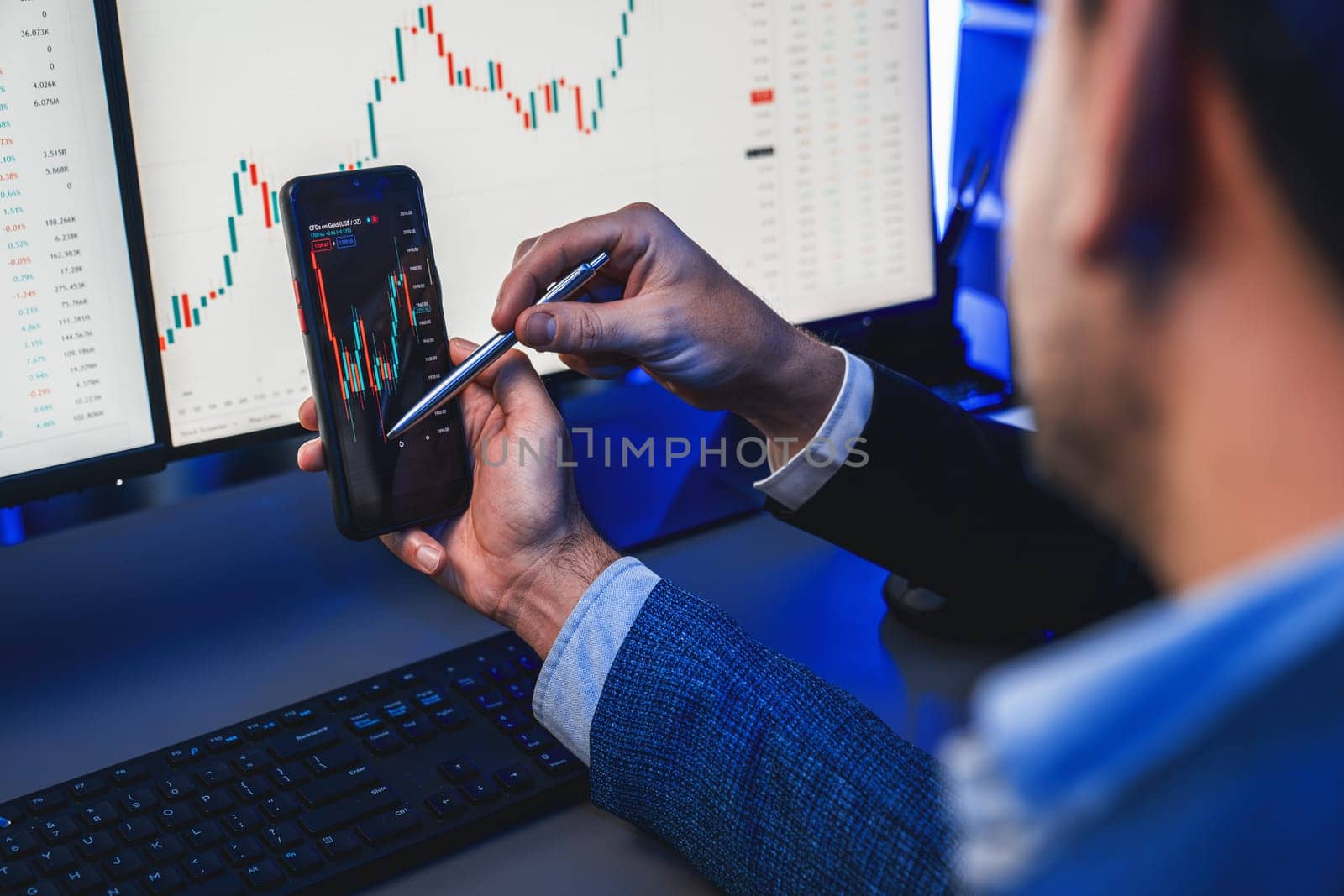 Two stock exchange traders researching data on smartphone and laptop screen server of dynamic digital currency. Investors analyzing market stock at decorative neon blue-light of workplace. Sellable.