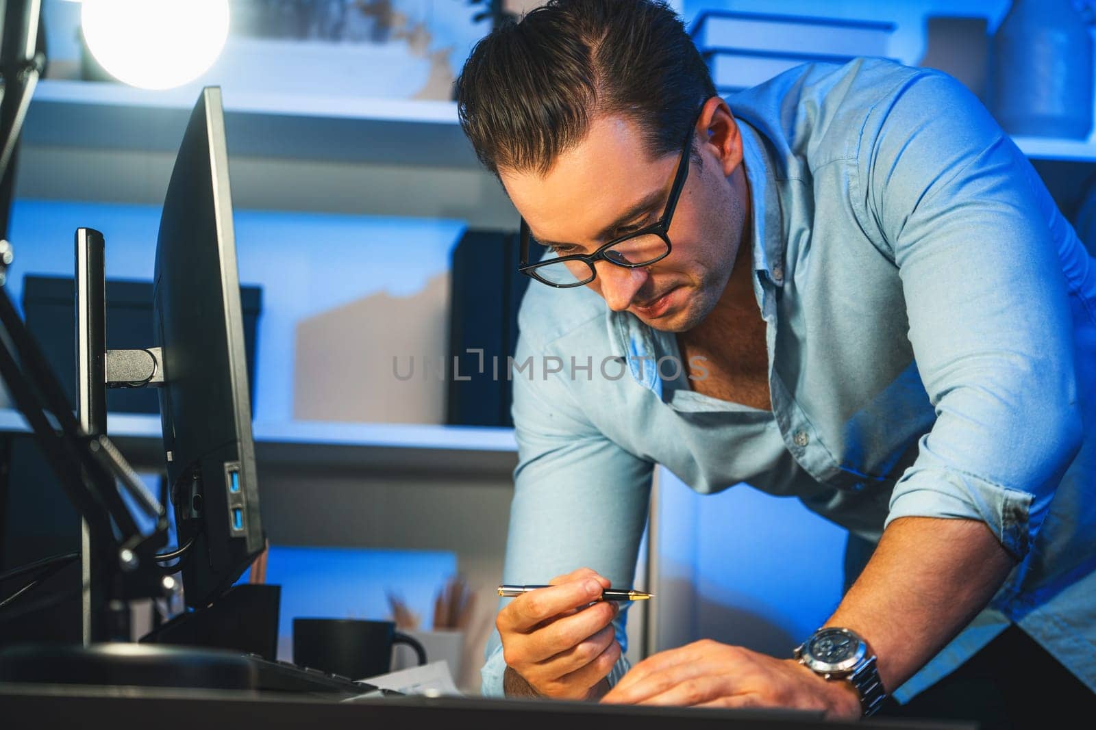 Professional businessman standing front at working desk, analyzing online business plan at night time. Concept of planning platform penetrated marketing to launch product on paperwork. Sellable.