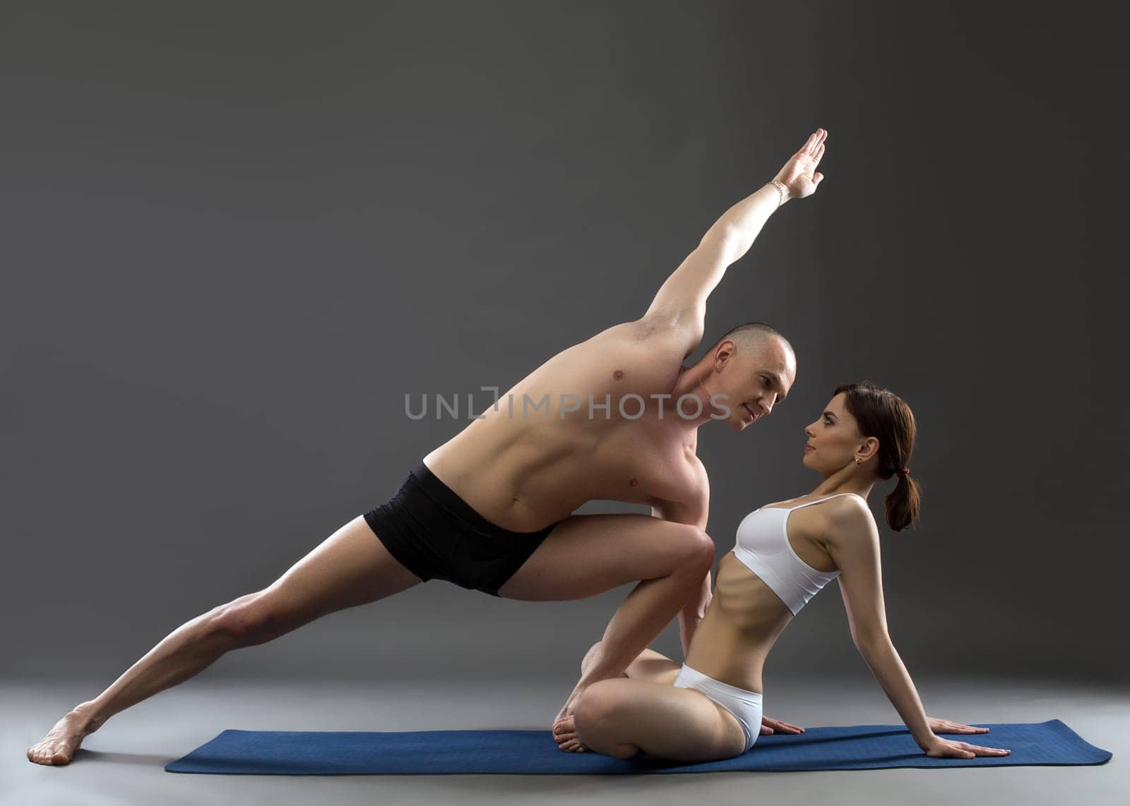 Studio shot of paired yoga, on gray background by rivertime