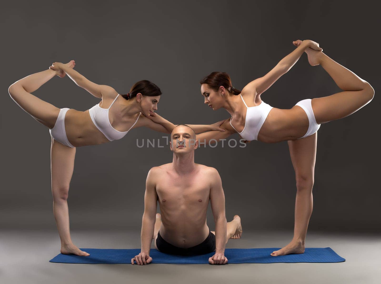 Yoga composition of flexible people posing at camera