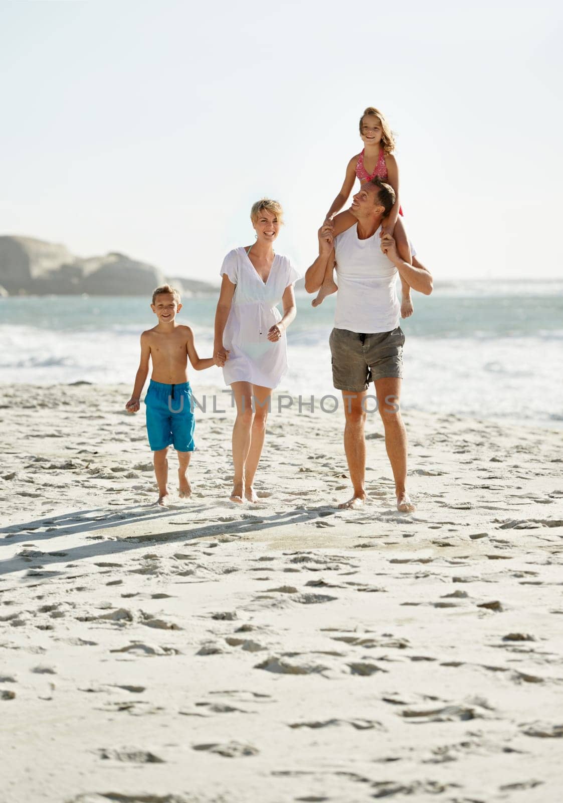 Parents, children and walking beach in summer or holiday on island or bonding, connection or vacation. Man, woman and kid on shoulders in Florida together or outdoor happiness, travel or hand holding by YuriArcurs