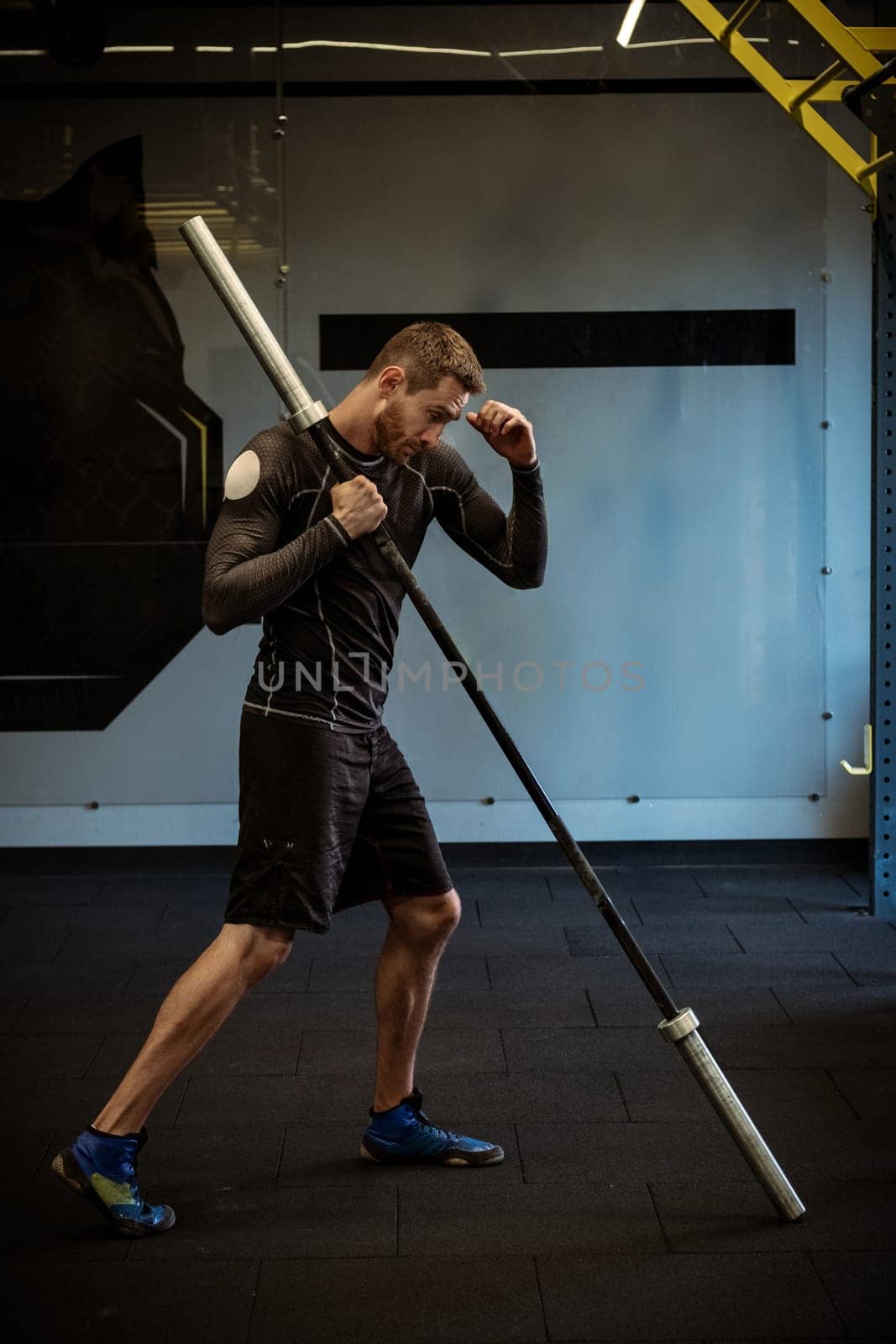 Boxer training explosive power with barbell in gym by nazarovsergey