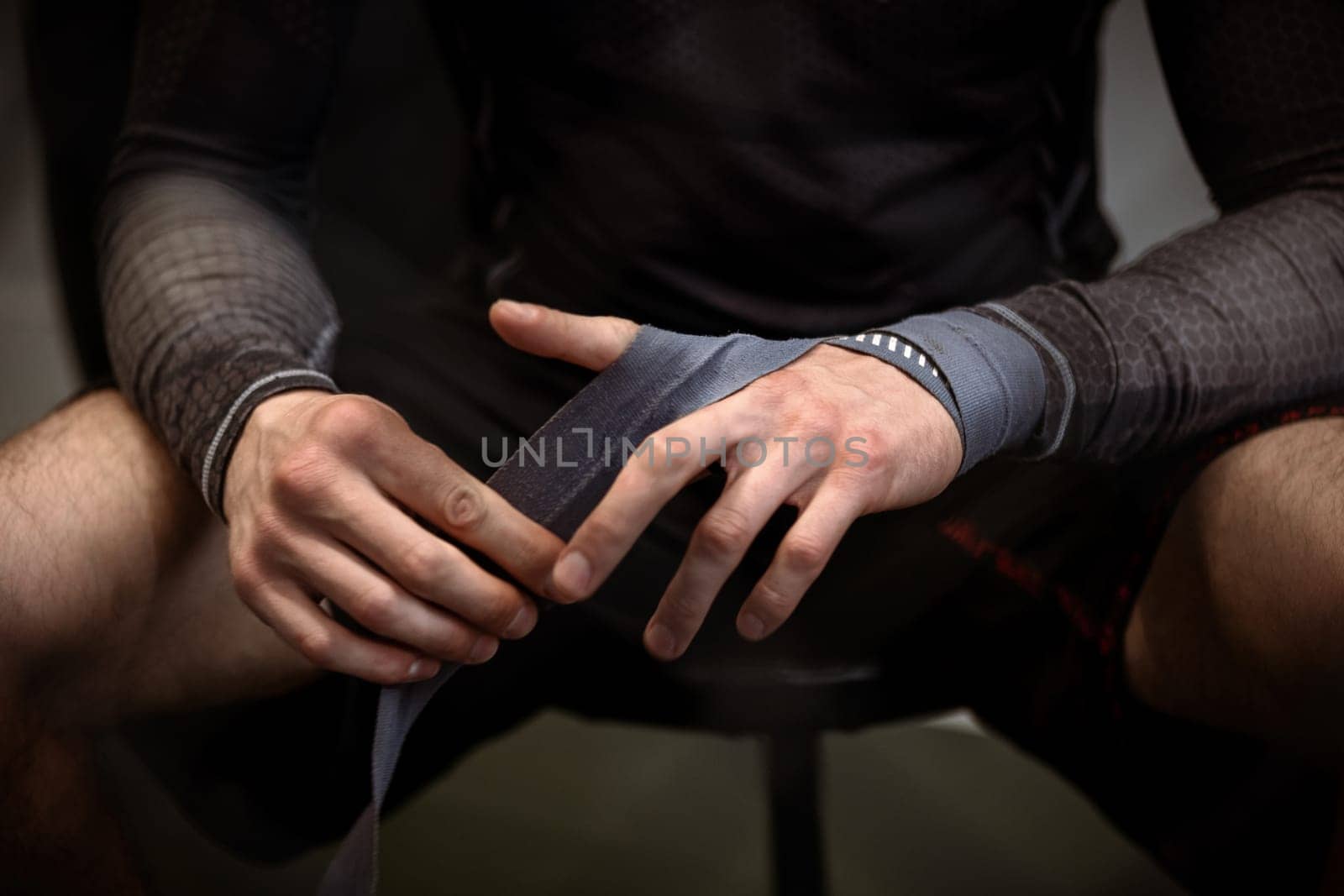 Boxer wrapping hands with boxing handwraps before training by nazarovsergey