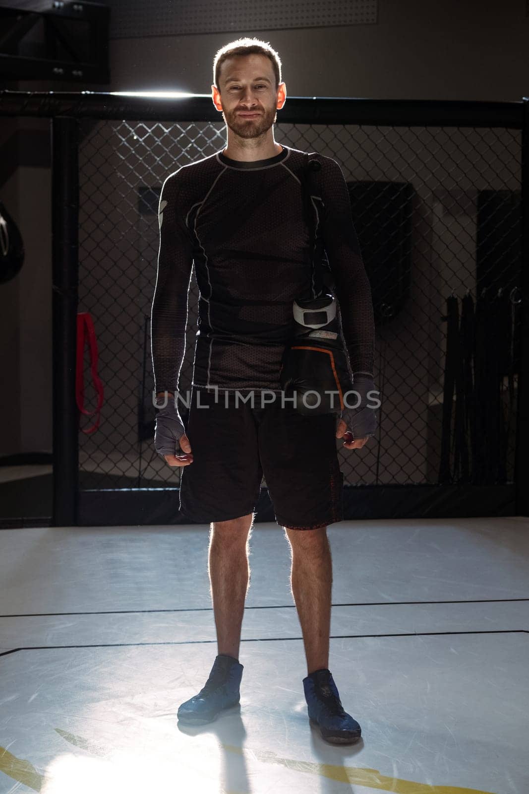 Confident smiling fighter in combat sports cage after successful training by nazarovsergey