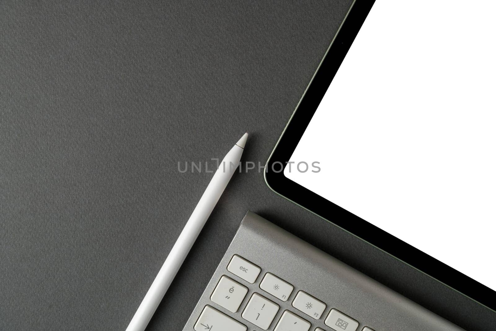 Tablet with blank screen, keyboard and stylus pen on dark gray background by Sonat