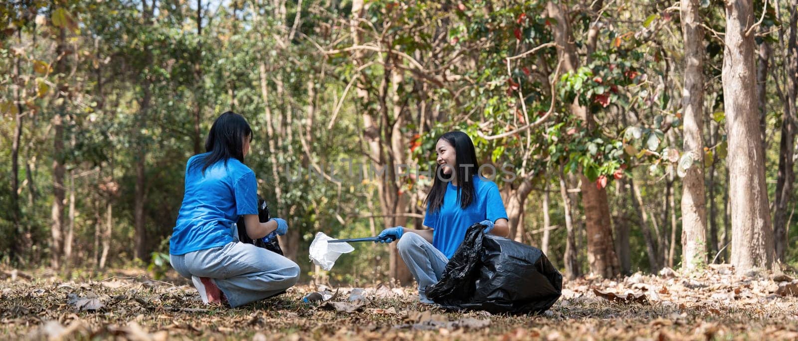 Volunteer collecting plastic trash in the forest. The concept of environmental conservation. Global environmental pollution. Cleaning the forest by nateemee