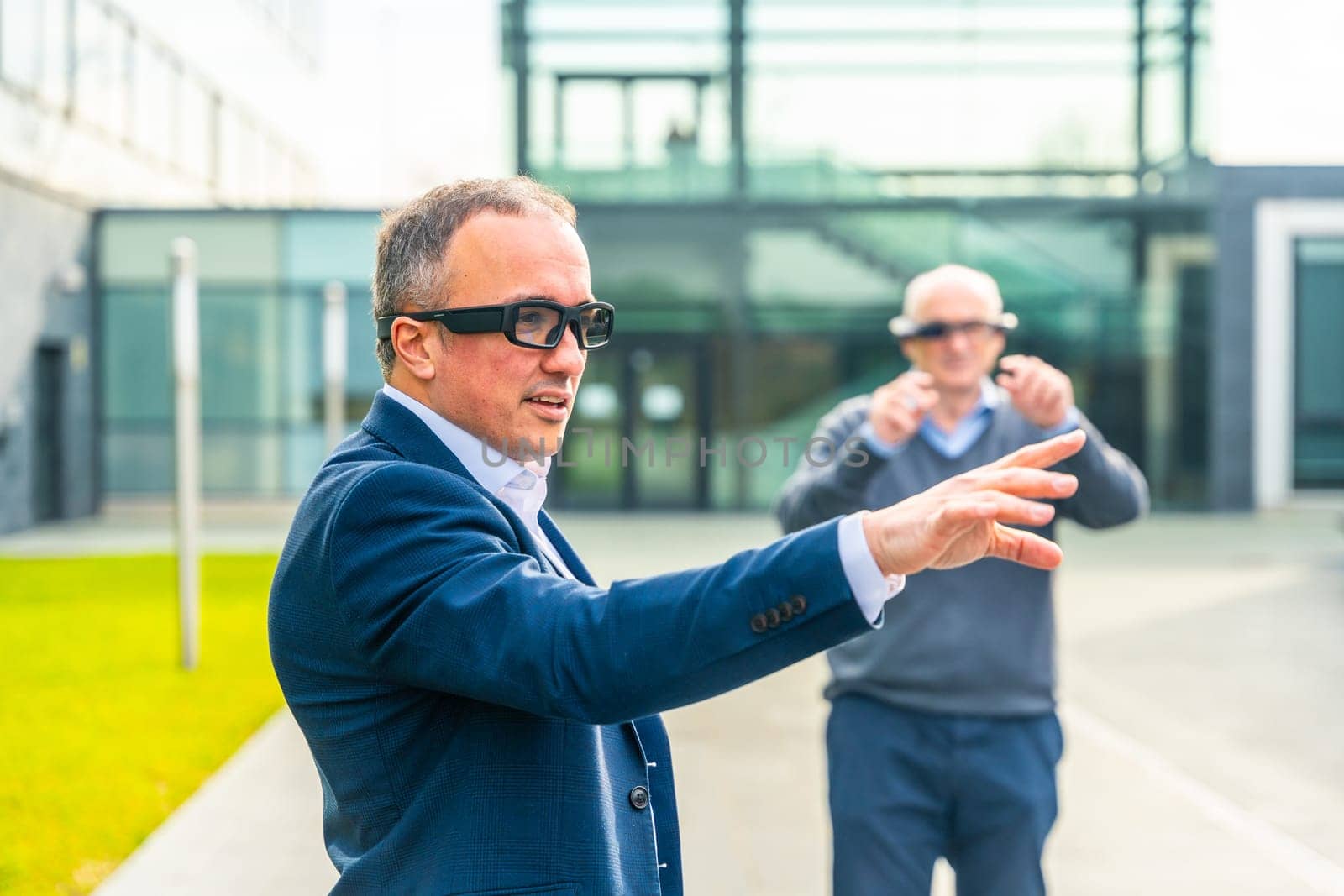 Two aged businessmen walking around in virtual reality while wearing VR goggles outside a financial complex