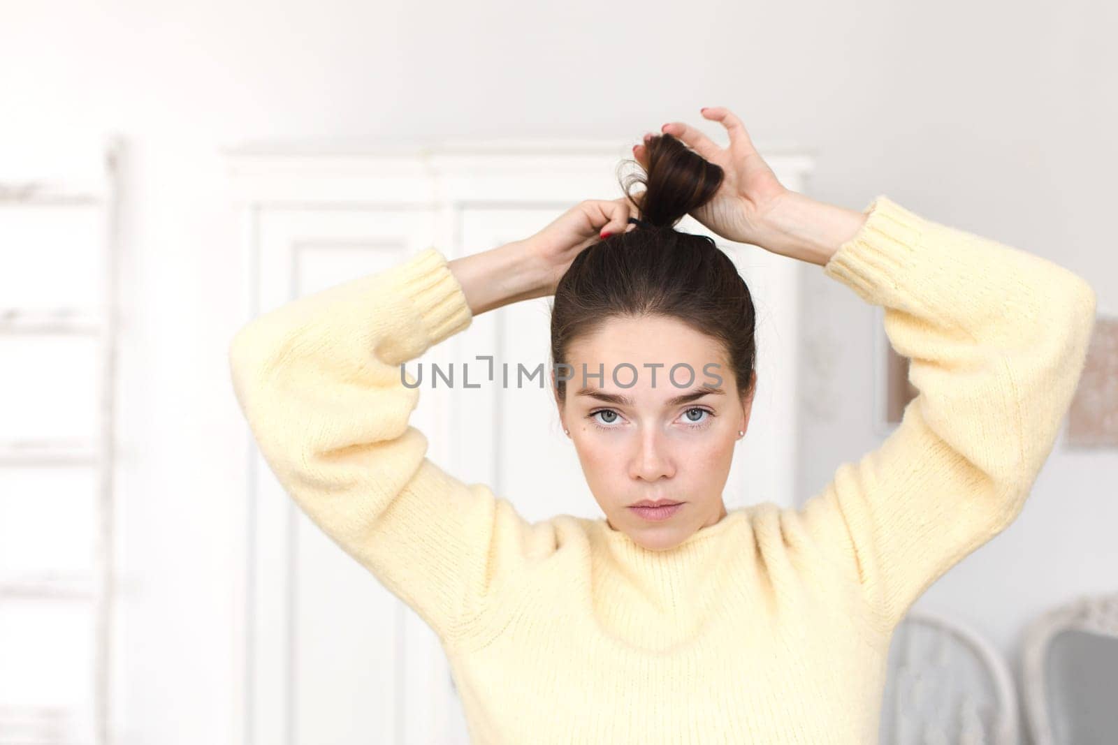Casual woman making hairstyle looking at camera by Demkat