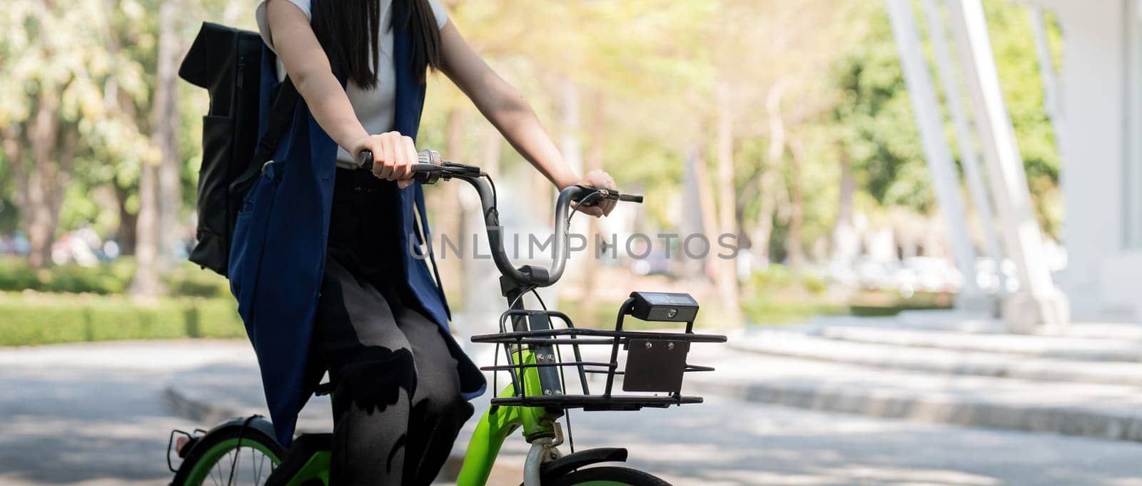Asian businesswoman in bicycle go to work at office. Bike commuting, happy businesswoman using eco transport, Concept of eco lifestyle by nateemee