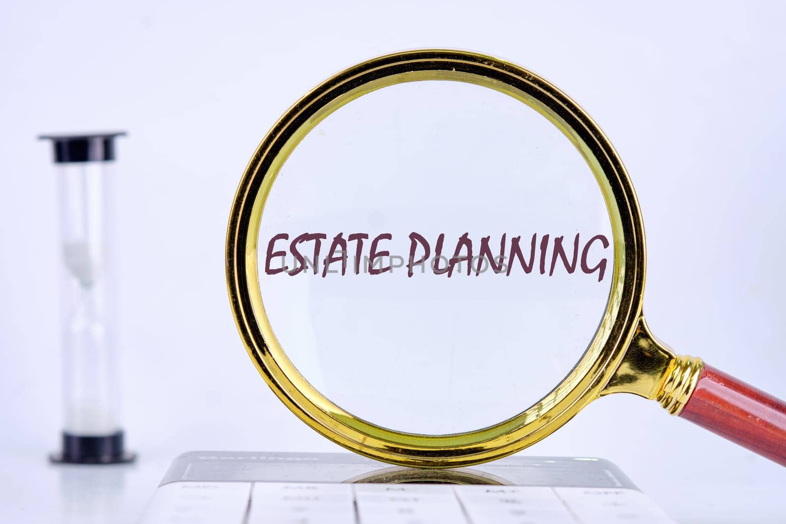 Estate Planning text writing through a magnifying glass on a gray background. Business concept