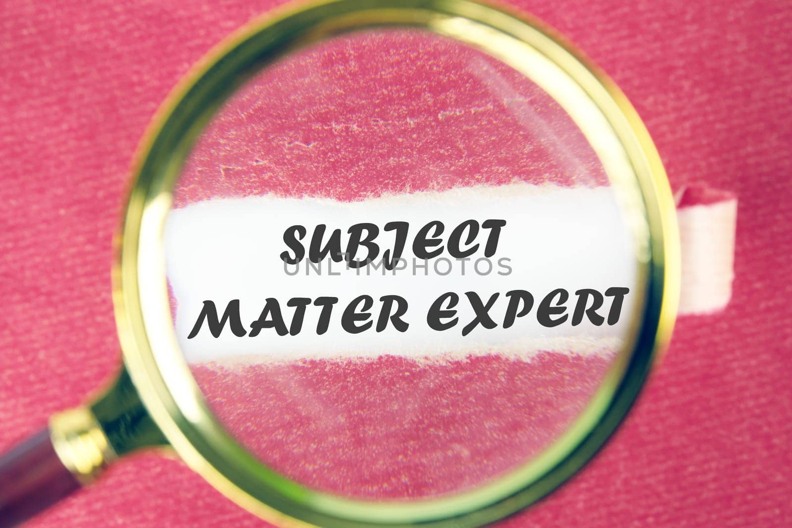 Text Subject Matter Expert through a magnifying glass under a torn piece of red paper