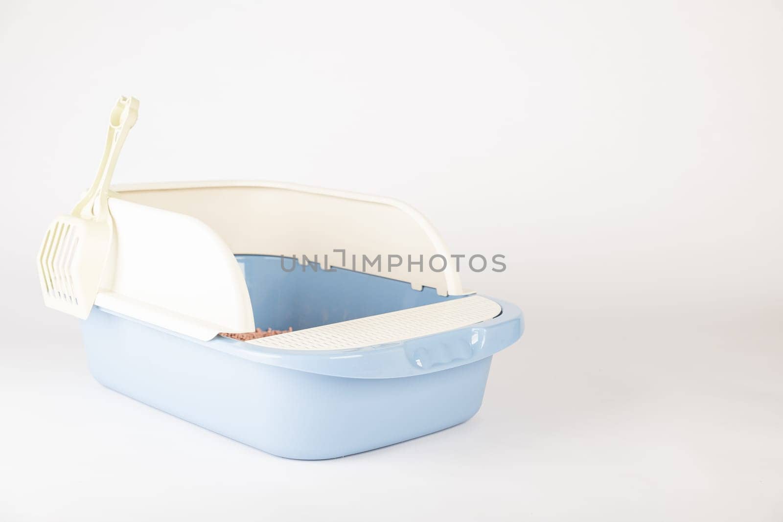 A clean and isolated cat litter toilet tray with scoop featuring a plastic crate on a white background. Ensure the hygiene and cleanliness of your pet's litter box.