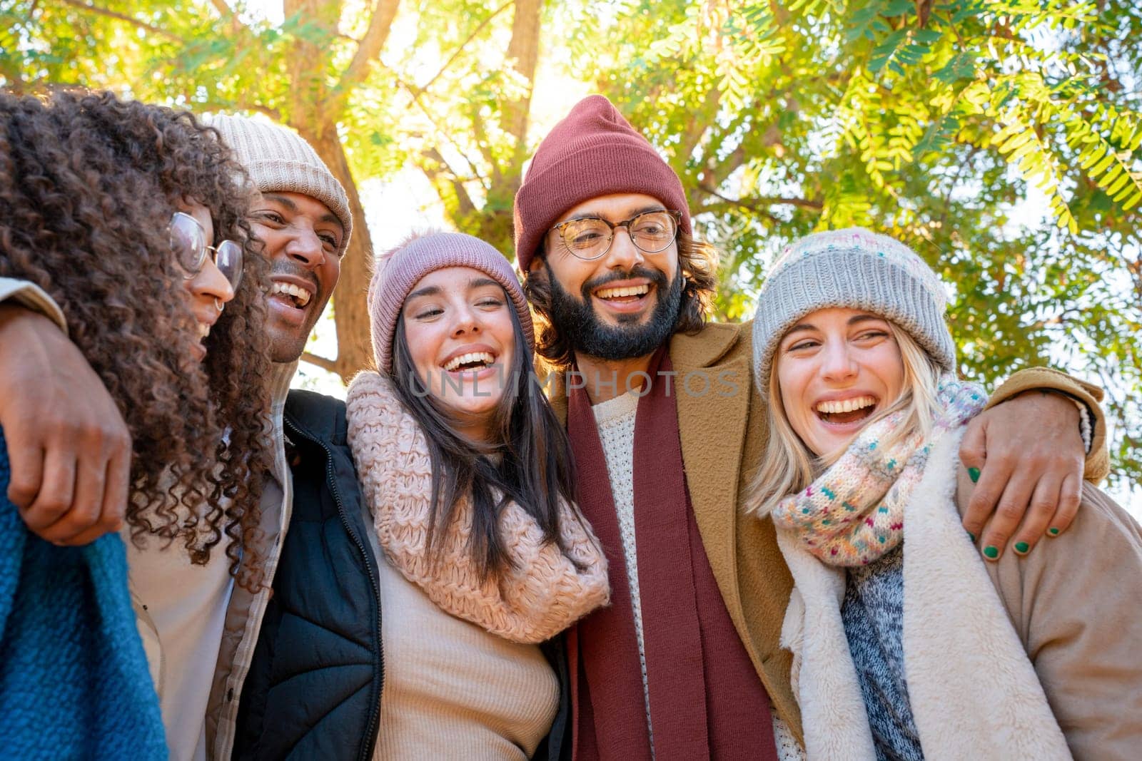 Friends are sharing a happy moment, smiling for a picture in a park enjoying the fun together. by PaulCarr