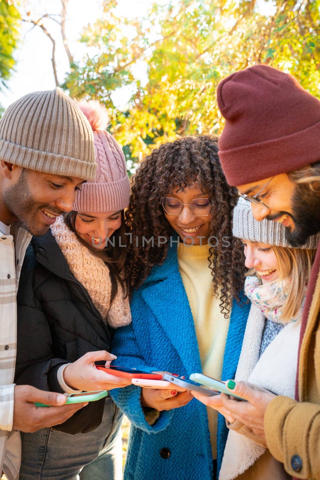 Low angle view of a group of young teenagers friends using cell phones. Concept of community millennial people addicted to technology. Social Media communication generation Z