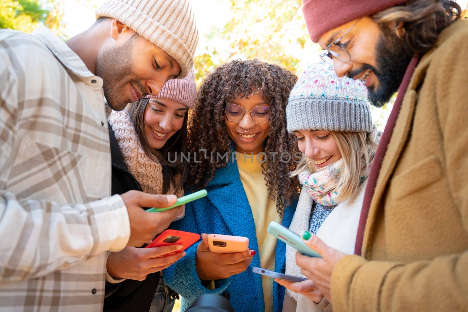 Group of young friends using cell phones. People addicted to technology. High quality photo
