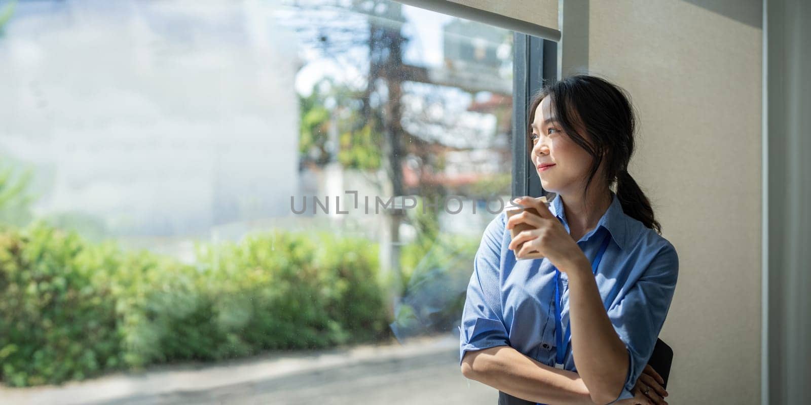 Professional business woman asian success in an office, smiling and holding a cup of coffee.
