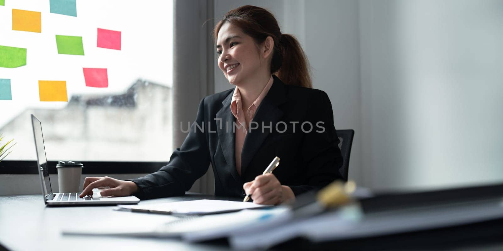 Close up image of businessman hand putting signature on contract document in presence of business partner.