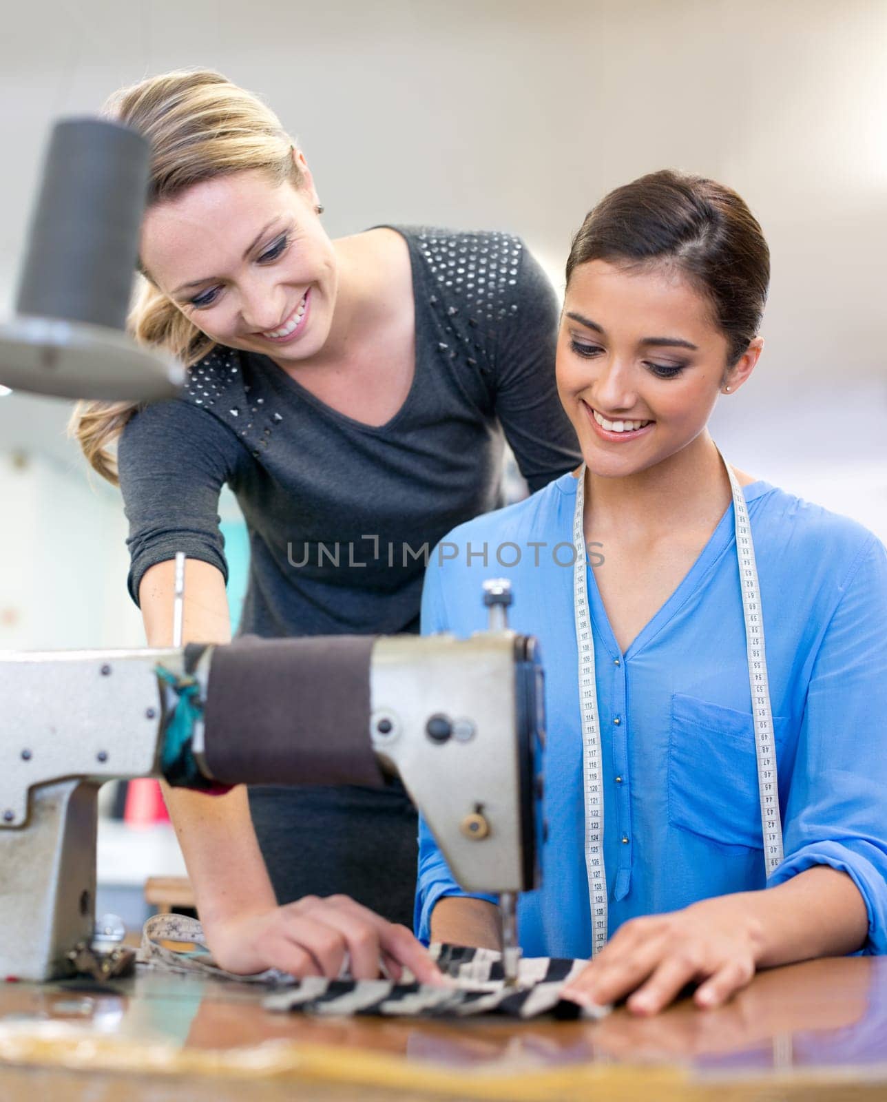 Designers, collaboration and sewing machine for manufacturing, coworkers and tailor on fabric. Women, teamwork and support on textile in clothing business, fashion planning and partnership on style.