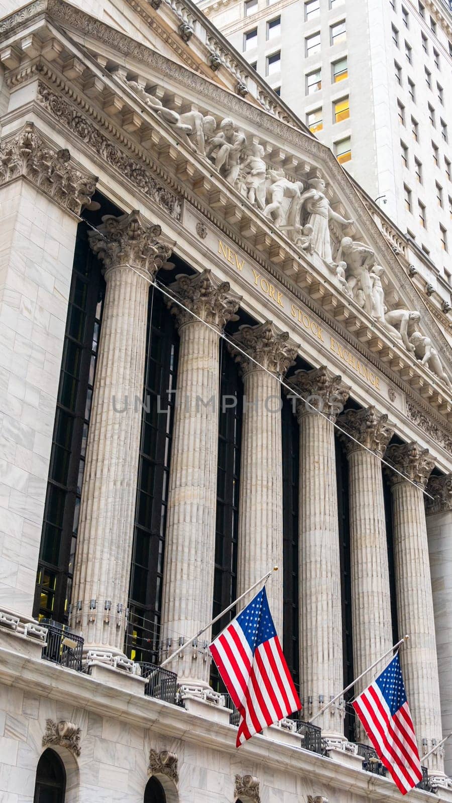 New York, USA - September 19, 2022: US national flags on the New York Stock Exchange building on
