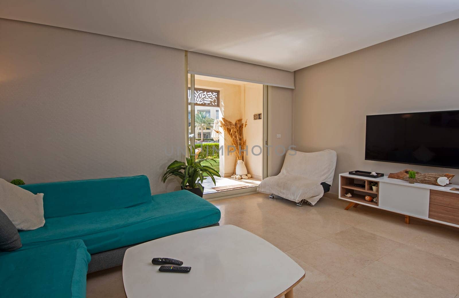 Living room lounge area in luxury apartment show home showing interior design decor furnishing with patio terrace