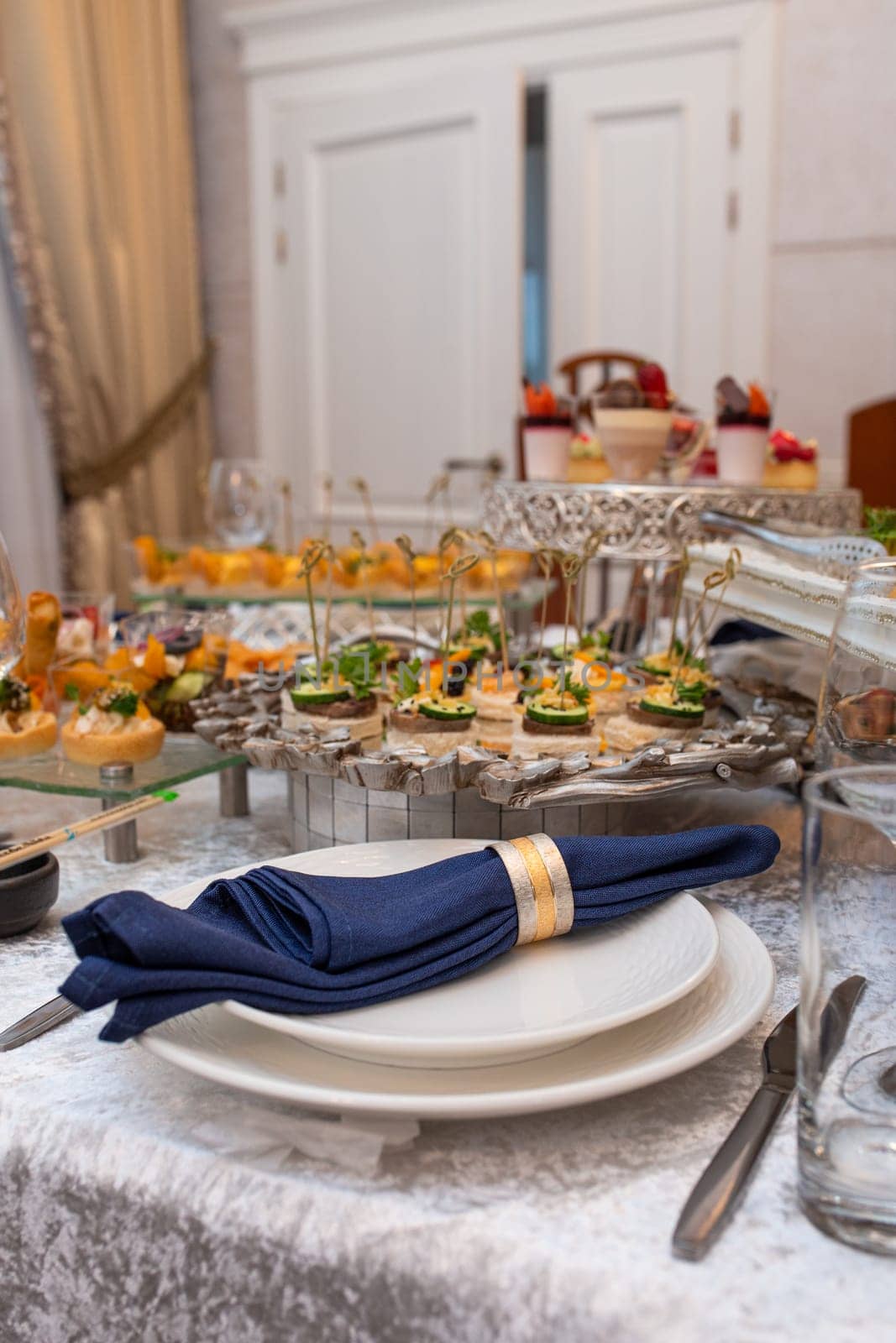 Elegant table setting with blue napkin and silverware by Pukhovskiy