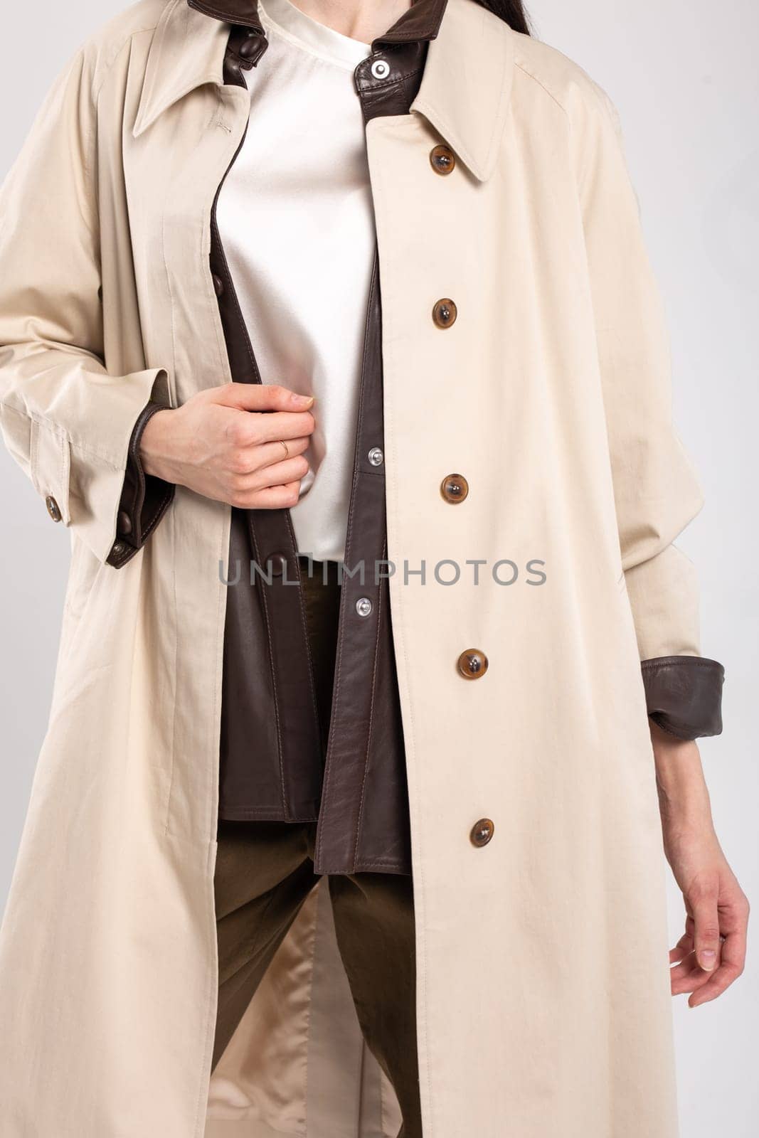 A sophisticated and timeless look for any occasion, this beige trench coat features a sleek and clean design with a hint of luxury.