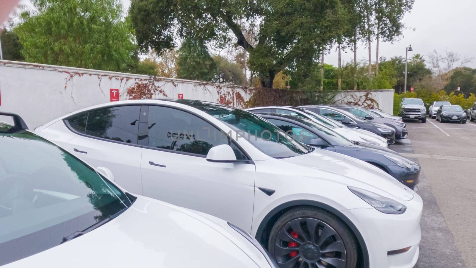 Los Angeles, California, USA-December 4, 2022-POV-At the Tesla Supercharging station in Miramar Beach, California, a line of sleek electric cars efficiently recharge their batteries.