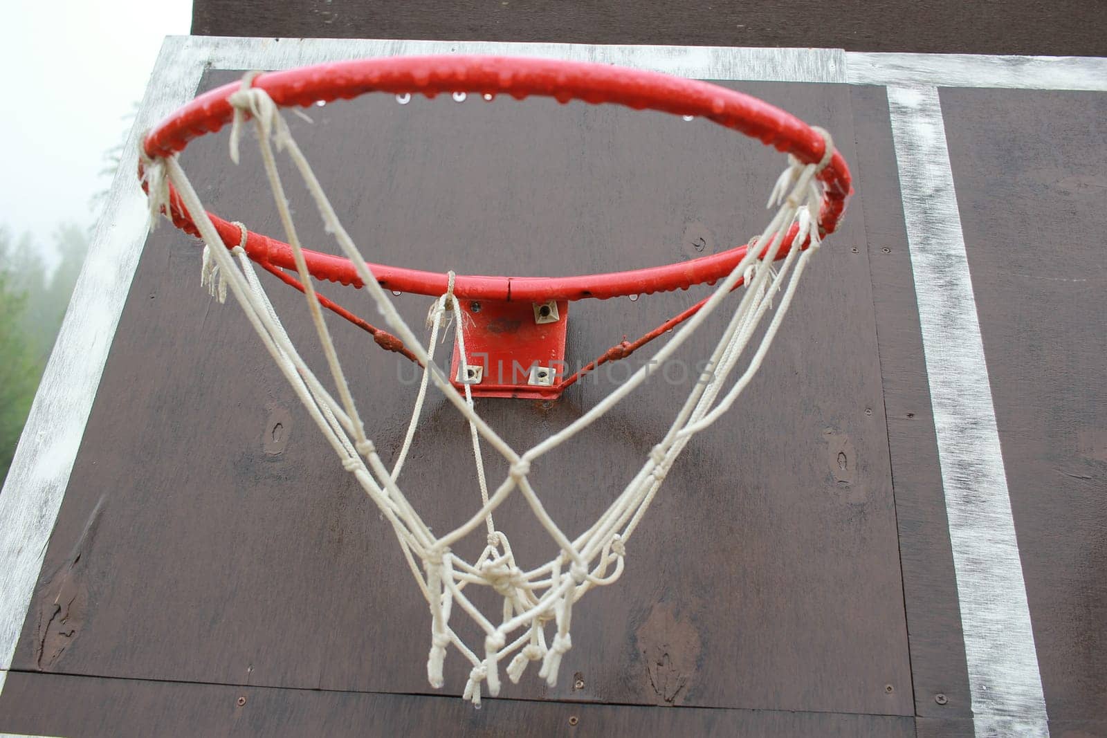 Photo a wet basketball hoop with a net after the rain. Outdoor games. Sports equipment.