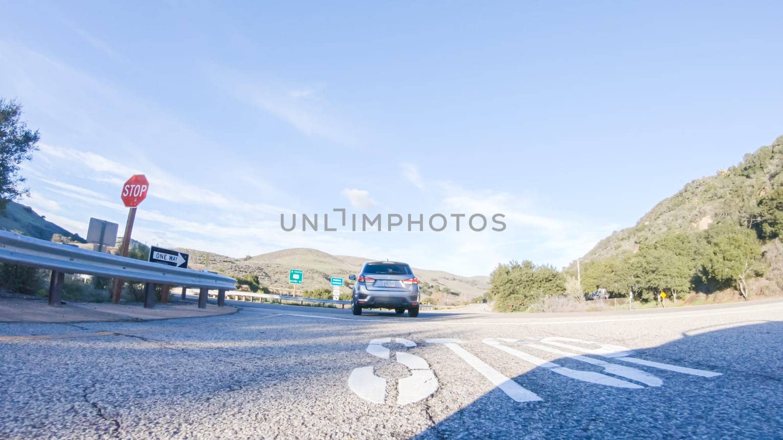 Los Angeles, California, USA-December 4, 2022-POV-Basking in the beauty of a sunny winter day, driving on HWY 1 near Las Cruces, California offers stunning views of the picturesque coastal landscape against a backdrop of clear blue skies.